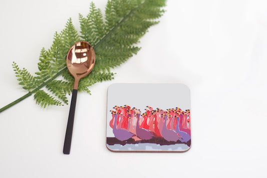 Coaster with colorful design, spoon, and fern on a white background