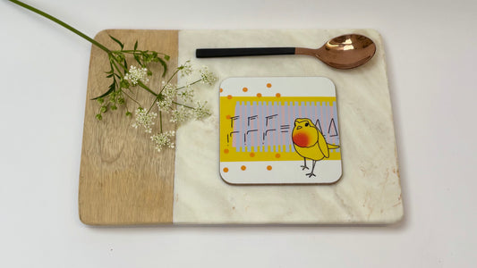 Coaster with a bird design on a wooden board with a white background