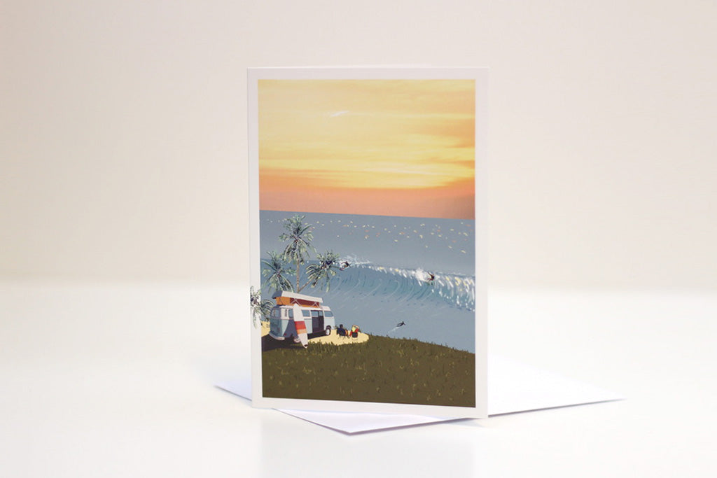 A greetings card with an illustration of a VW campervan and a sunset beach scene.