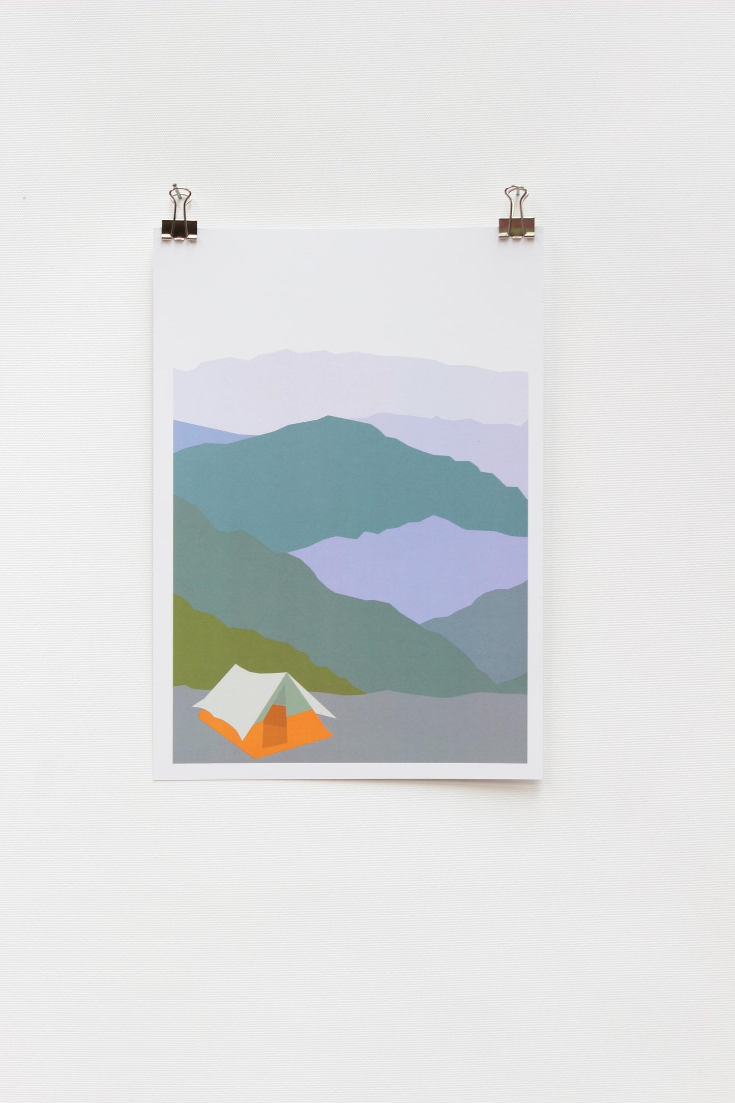 A digital print of a tent in a mountainous landscape, framed and displayed on a white wall using two clip hinges.