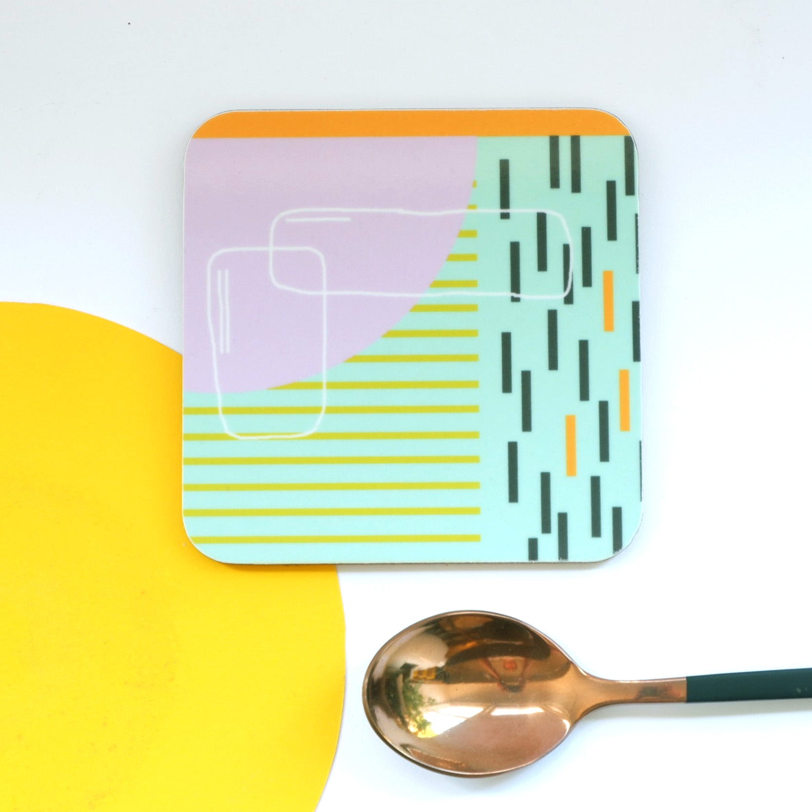 A set of square coasters with abstract blue and orange geometric patterns, one coaster is placed under a spoon to show the design.