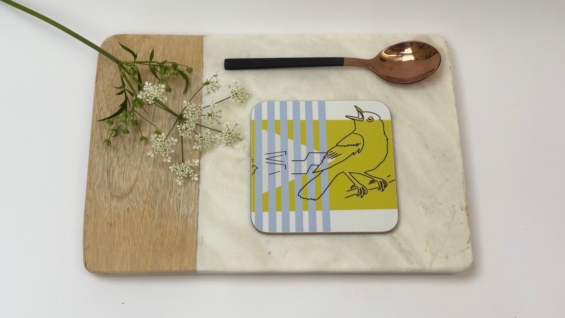 Coaster with a design on a marble surface with a wooden board and spoon.