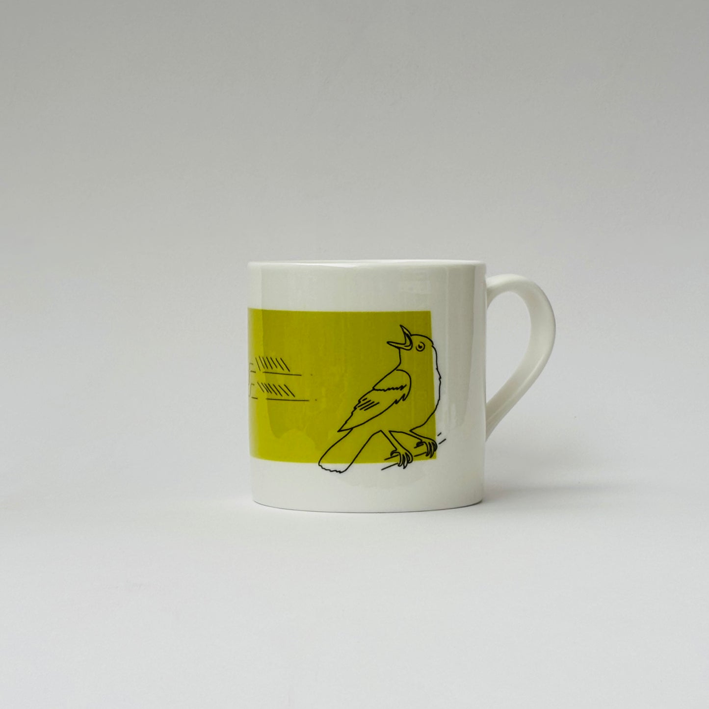 White mug with a green accent featuring a bird illustration on a white background