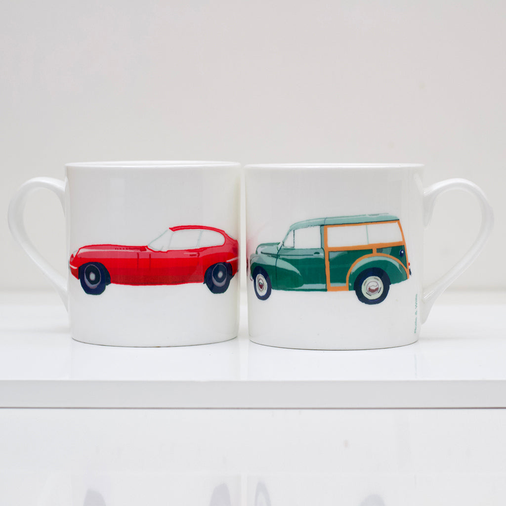 Two mugs with car illustrations on a white surface