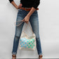 Person holding a tote bag with butterfly design against a plain background