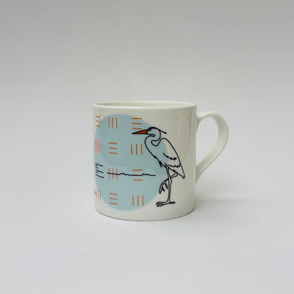 White mug with a bird design on a light gray background