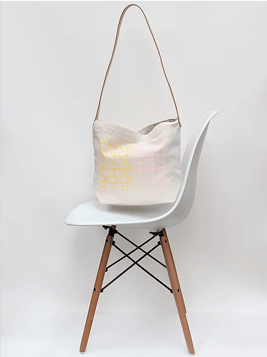 White chair with a light-colored bag hanging on it against a white background