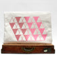 White pouch with pink geometric pattern on a white background