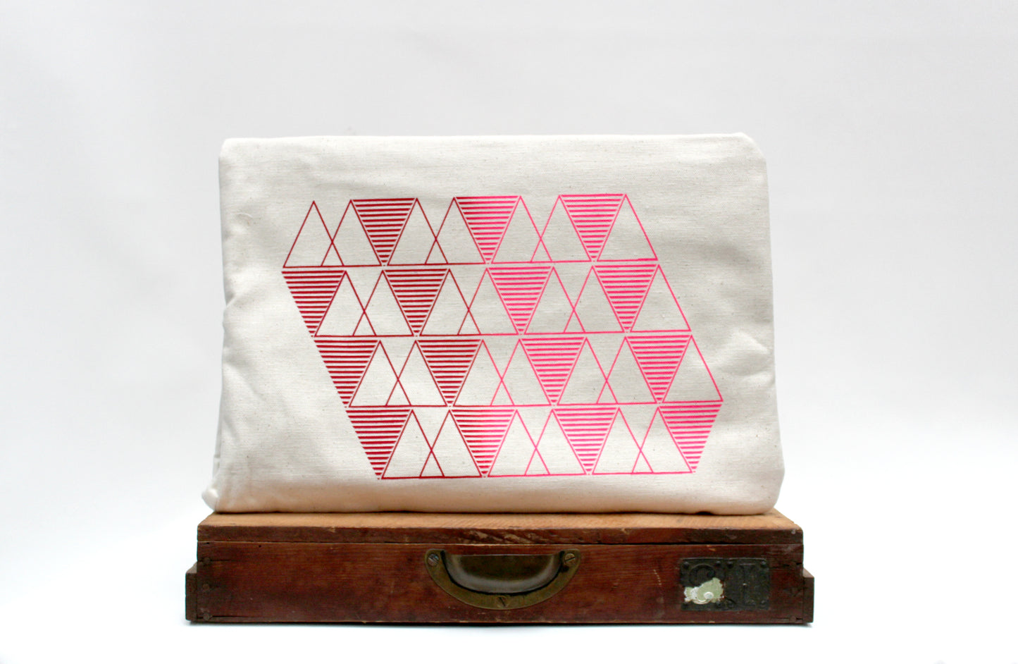 White pouch with pink geometric pattern on a white background