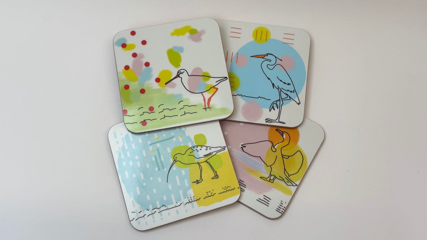 Set of four colorful coasters with bird illustrations on a white background