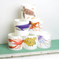 A set of bone china mugs with various underwater animal illustrations, displayed in a stacked arrangement on a shelf.