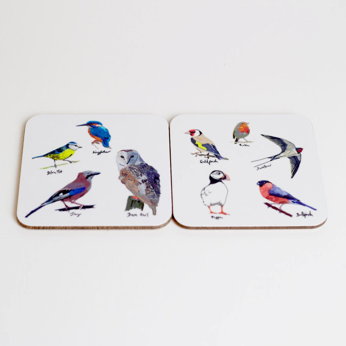 A set of two square coasters with various illustrations of British birds on them, displayed on a neutral background.