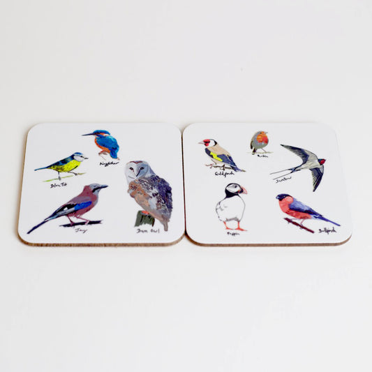 A set of two square coasters with various illustrations of British birds on them, displayed on a neutral background.