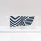 A two-tone bone china mug with a geometric camouflage pattern design.