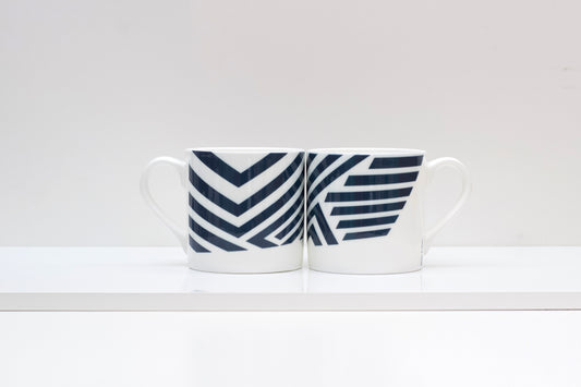 A two-tone bone china mug with a geometric camouflage pattern design.