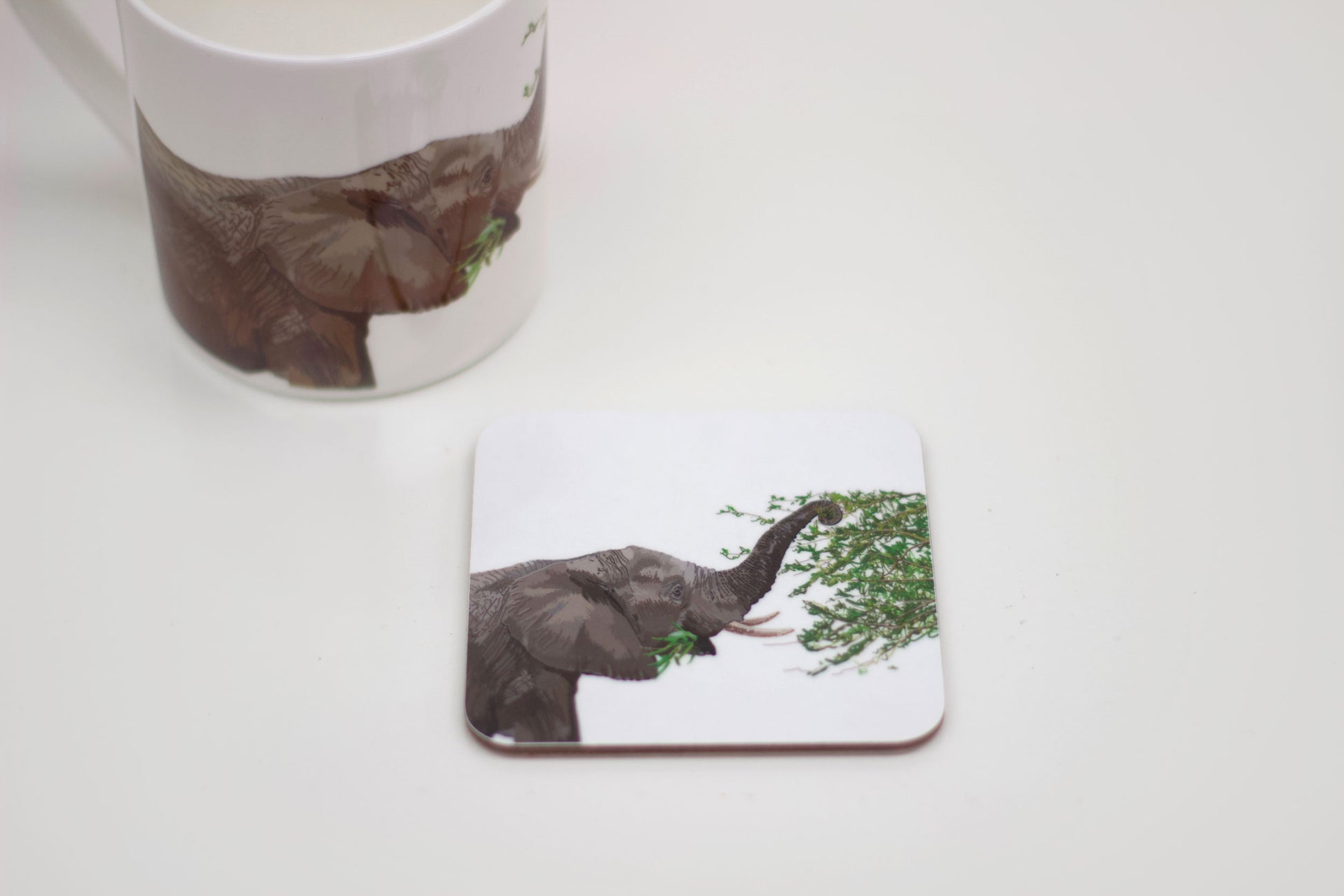 A coaster featuring an illustration of an elephant with leaves on its trunk, part of the Africa collection.