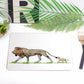 A white placemat with an illustration of a lion and its cub, presented on a table with cutlery and plants in the background.