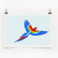 A colorful digital print of a parrot signed by an artist, displayed on a wall mount against a white background.