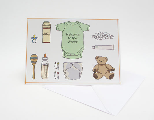 A greeting card with illustrations of a babygrow, a teddy bear, a pacifier, and other baby-related items arranged neatly on the front.