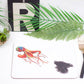 A decorative placemat featuring an artistic depiction of an octopus with ink, placed on a table with a plant, a fork, and a coaster.