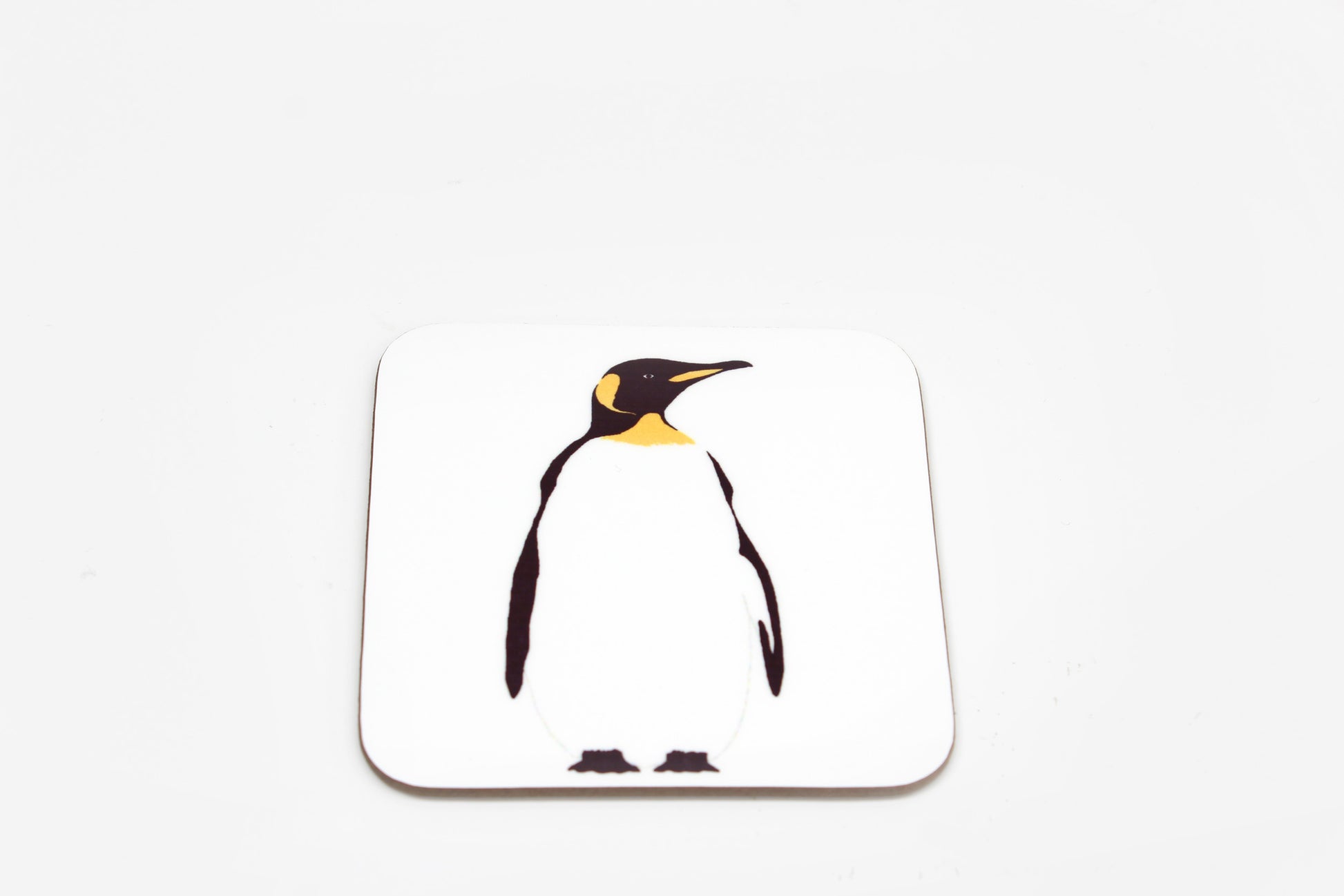 A square white coaster with a central penguin design.