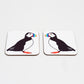 Two square coasters with a drawing of a puffin in the center with a rainbow-colored beak. Both have a white background.