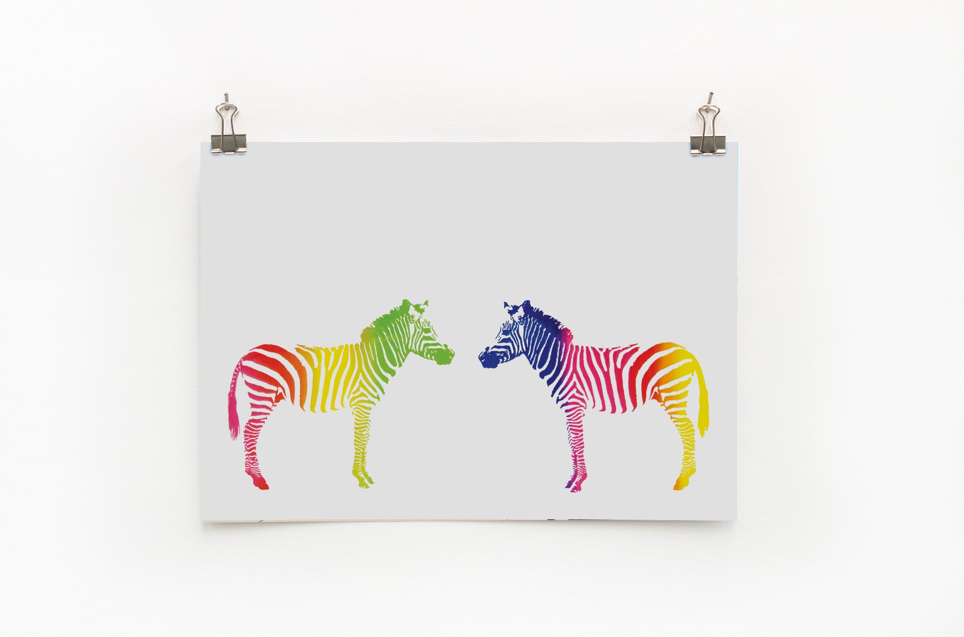 A digital print featuring two zebras in a rainbow color stripe pattern, mounted on a wall.