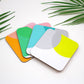 A set of colorful dipped coasters in various shades of orange, pink, lime, and grey, displayed on a white surface with a green palm leaf in the background.