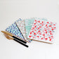 A set of four placemats with various sound-related patterns including geometric and abstract designs, displayed on a white background with a fork and knife to the side.