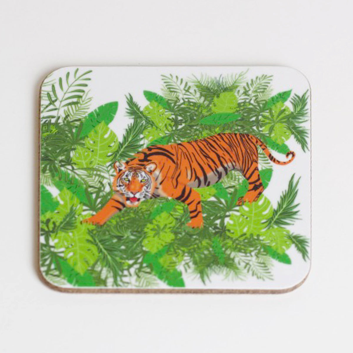 A square coaster with a hand-drawn tiger design, jungle background, and green foliage.
