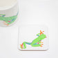 A square coaster with a hand-drawn tree frog design, part of the Jungle Collection, placed on a white surface next to a white mug with a similar design.