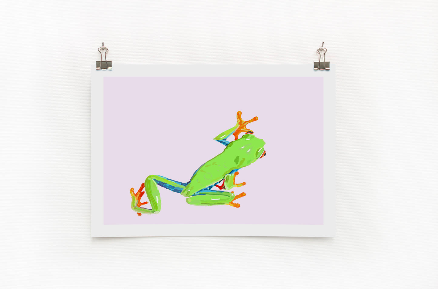 Digital print of a green and orange tree frog on a purple background, framed and hanging on a wall.