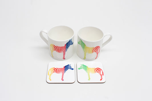 Two square coasters with a multicolored zebra pattern on a white background, displayed on a white surface.